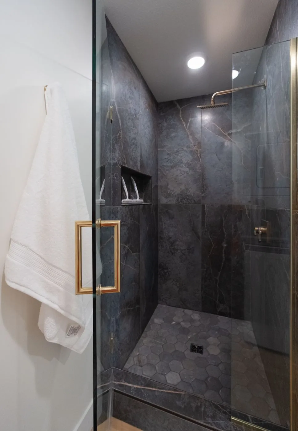 Walk-in shower with dark marble tile